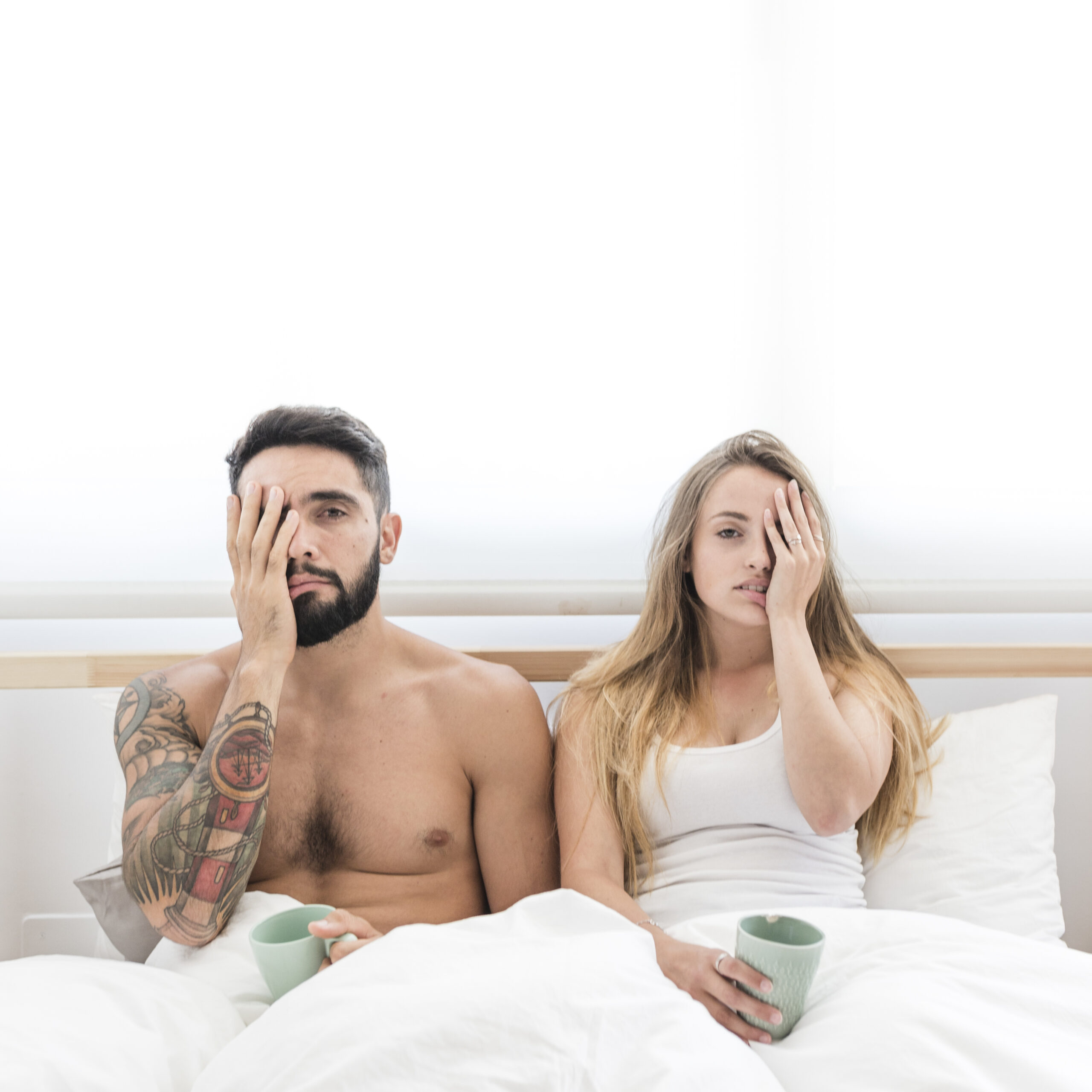 young couple sitting bed covering their one eye scaled